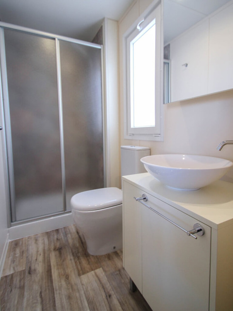 Modern bathroom with shower, toilet, and vessel sink in Park Riviera lodge at Campsite Park Umag, Croatia.