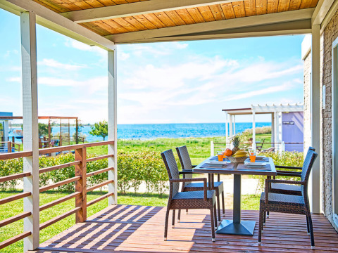 Covered terrace with sea view at Park Riviera 2-bedroom lodge, Campsite Park Umag, Croatia, table set for meal.