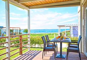 Covered terrace with sea view at Park Riviera 2-bedroom lodge, Campsite Park Umag, Croatia, table set for meal.