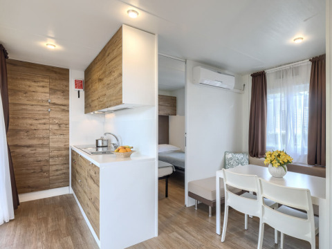 Modern Park Riviera «EVO» lodge at Campsite Park Umag in Croatia featuring a kitchen, dining, and living area.