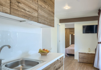 Cucina moderna del lodge Park Riviera «EVO» con dettagli in legno e vista sulla camera, Park Umag.
