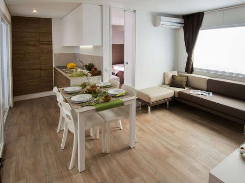 Lodge moderne Park Riviera « EVO » au camping Park Umag en Croatie, avec cuisine, salle à manger et salon.