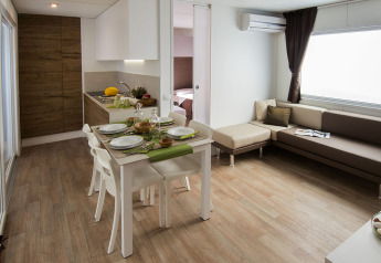 Lodge moderne Park Riviera « EVO » au camping Park Umag en Croatie, avec cuisine, salle à manger et salon.