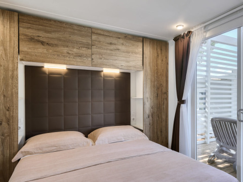 Bedroom at Park Riviera «EVO» lodge at Campsite Park Umag, Croatia, with double bed and patio access.
