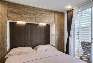 Bedroom at Park Riviera «EVO» lodge at Campsite Park Umag, Croatia, with double bed and patio access.