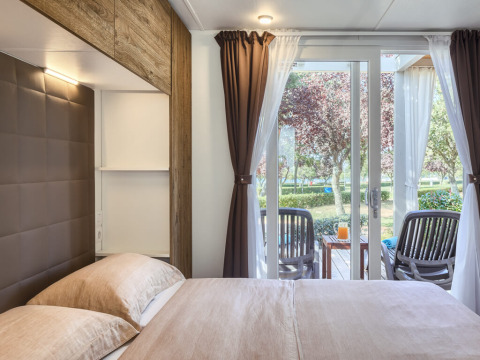 Bedroom view at Park Riviera EVO, Campsite Park Umag in Croatia, with terrace chairs and table outside window