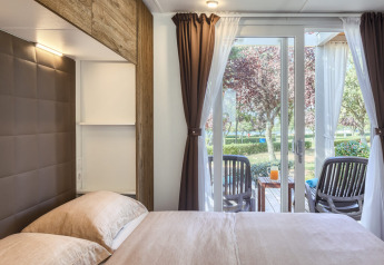 Vue de chambre au Park Riviera EVO, camping Park Umag en Croatie, avec terrasse, chaises et table à l'extérieur
