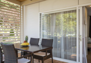 Patio with wicker chairs, dining table and fruit bowl at Park Riviera «EVO», Campsite Park Umag, Croatia.
