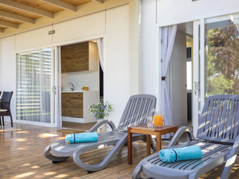 Sunny terrace with lounge chairs, blue towels, and juice at Park Riviera «EVO», Campsite Park Umag, Croatia.