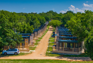 Modern cabins lined up with green trees at Park Riviera «Adria Garden», Campsite Park Umag, Croatia, sunny day.