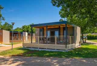 Modern lodge at Park Riviera «Adria Garden» in Campsite Park Umag, Croatia, surrounded by sunny greenery.