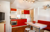 Cucina e zona pranzo moderne nella casa Padova Home al Valamar Camping Padova, Croazia, con mobili rossi.