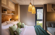 Camera moderna a Hilltop Green Chalet, Valamar Camping Padova, Croazia, con luce accogliente e arredamento verde.
