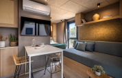 Interni moderni dello chalet Hilltop Green al Valamar Camping Padova in Croazia con soggiorno e zona pranzo.