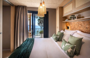 Camera moderna di lodge con cuscini verdi e vista spettacolare sul mare al Valamar Camping Padova, Croazia.