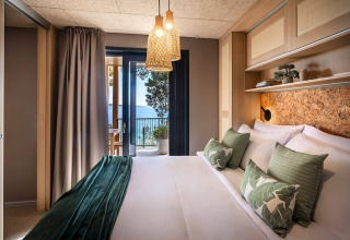 Moderne lodge med grønne puder, naturlige toner og spektakulær havudsigt på Valamar Camping Padova, Kroatien.