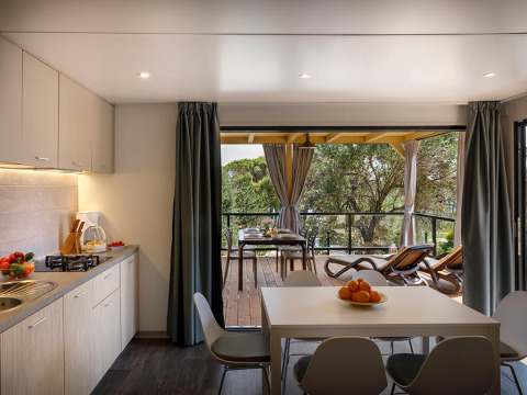 Moderne køkken og spiseområde i Padova Suite på Valamar Camping Padova, med udsigt til træbeklædt terrasse.