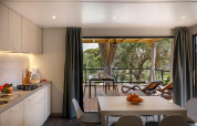 Cucina e zona pranzo moderne nella Padova Suite al Valamar Camping Padova, vista su terrazza e alberi.