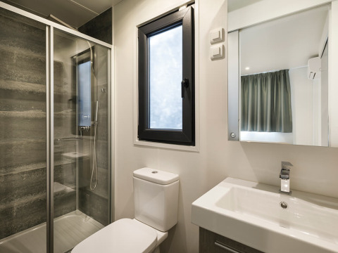 Moderne badeværelse i en suite på Valamar Camping Padova i Kroatien med bruser, toilet og vask.
