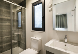 Moderne badeværelse i en suite på Valamar Camping Padova i Kroatien med bruser, toilet og vask.