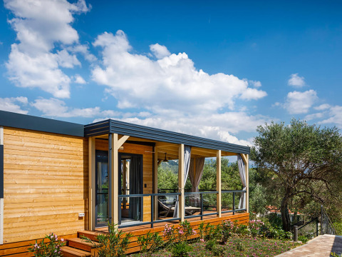 Udendørs billede af en moderne træ-lodge med overdækket terrasse på Valamar Camping Padova i Kroatien