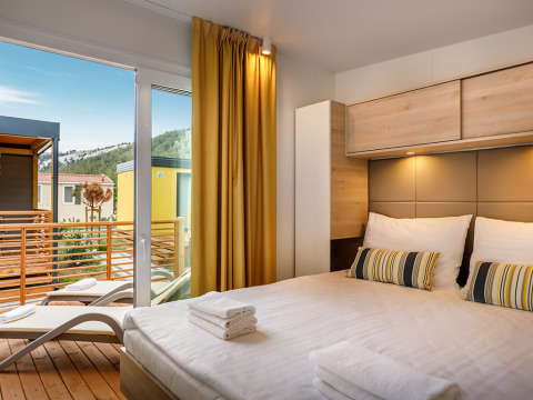 Moderne slaapkamer in Vela Bay Home met terraszicht in Valamar Camping Baška, Kroatië.