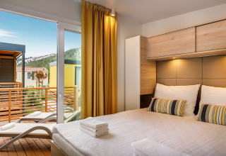 Moderne slaapkamer in Vela Bay Home met terraszicht in Valamar Camping Baška, Kroatië.