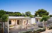 Moderne lodge bij Krk Home, Valamar Camping Krk in Kroatië, met veranda en gasten die buiten genieten.