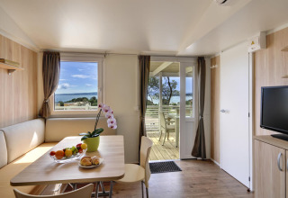 Interieur van Krk Home lodge bij Valamar Camping Krk in Kroatië, met zeezicht en een terras.