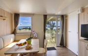 Lichte leefruimte in Krk Home-lodge bij Valamar Camping Krk, Kroatië, met terras en zeezicht.