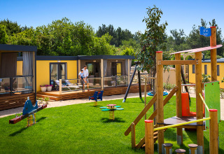 Speeltuin en moderne lodges bij Bella Vista Home, Valamar Camping Krk, Kroatië, met buiten spelende families.