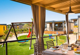 Uitzicht vanaf het terras van Bella Vista Home bij Valamar Camping Krk, Kroatië, met speelplaats en eettafel.