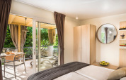 Moderne slaapkamer in het Bella Vista Chalet op Valamar Camping Krk, Kroatië, met terras en buiteneethoek.