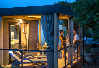 Aftenbillede af Bella Vista Chalet på Valamar Camping Krk, hvor et par nyder deres terrasse i Kroatien.