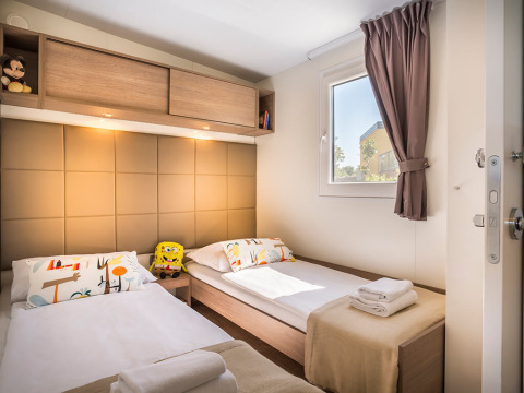 Slaapkamer met twee eenpersoonsbedden, modern design, speelgoed en raam in Bella Vista Home Garden terrace.
