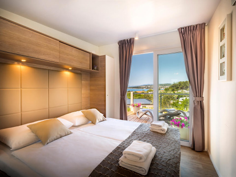 Modern slaapkamer bij Bella Vista Home met terras en spectaculair zeezicht in Valamar Camping Krk, Kroatië.