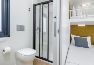Modern bathroom with shower and adjoining sleeping area at Camping Home «Sea View», Arena Stupice, Croatia.