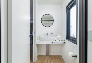 Baño moderno en Camping Home 'Sea View' en el Camping Arena Stupice, Croacia, con suelo de madera.