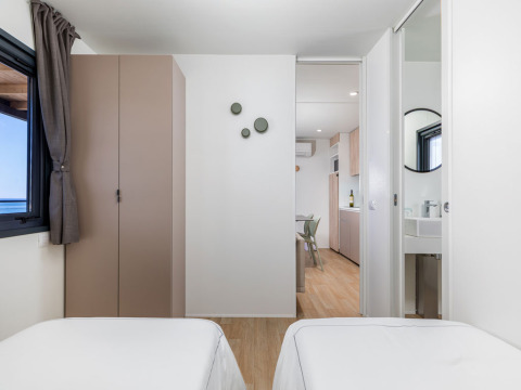 Lodge moderno Camping Home «Sea View» en el Camping Arena Stupice, Croacia, con vista al mar desde el dormitorio.