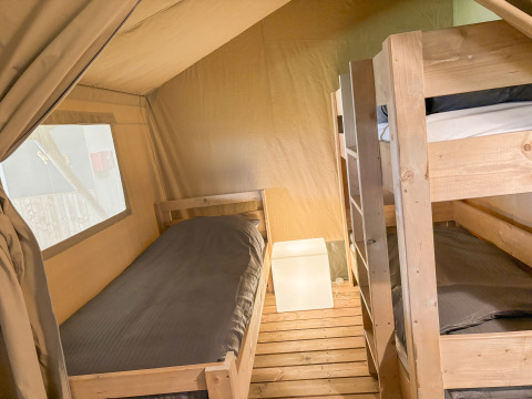 Interior of Safari tent at Campsite de Boerenzwaluw in the Netherlands with bunk beds and a single bed.