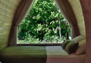 Schlafzimmer in einer Holzhütte mit großem Fenster und Naturblick, Cabin at Thuysgrond, Niederlande.