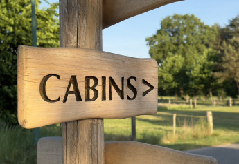 Letrero de madera con la palabra 'CABINS' señala hacia las cabañas de Thuysgrond en los Países Bajos.