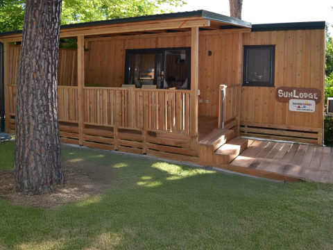 Mobil-home en bois SunLodge Catalpa au camping Village Marina di Venezia, Italie, avec terrasse et pelouse.