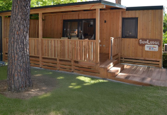 Casa móvil SunLodge Catalpa de madera en el Village Marina di Venezia, Italia, con porche y césped.