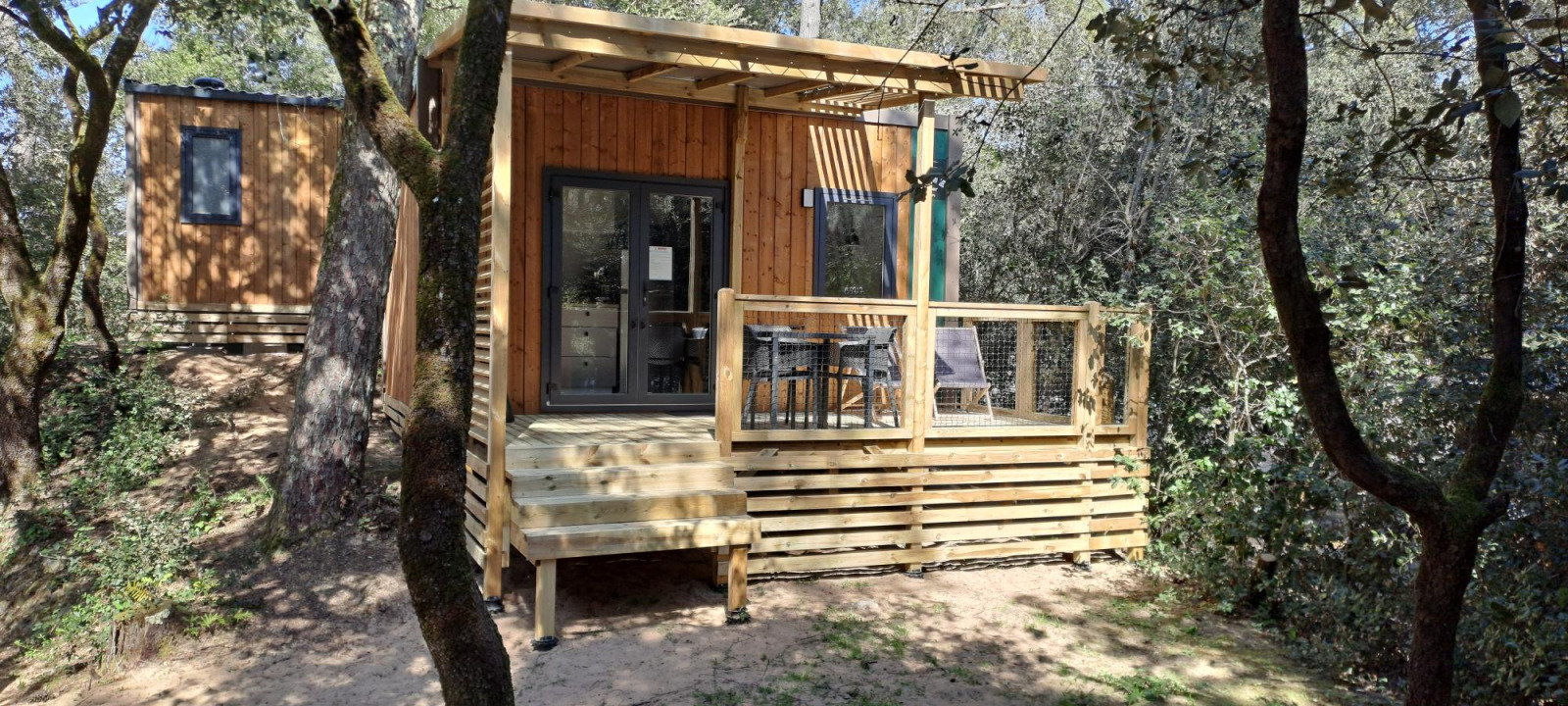 Homeflower Premium 18m² houten lodge met terras in het bos bij Flower Camping La Sagne, Frankrijk.