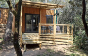 Homeflower Premium 18m² houten lodge met ruim terras in het groen bij Flower Camping La Sagne, Frankrijk.