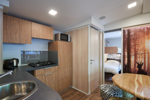 Modern kitchen and dining area inside SunLodge Mobile Home Katsura at Campsite Pra'delle Torri, Italy.