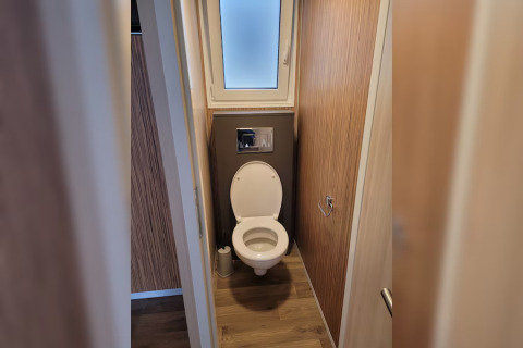Bathroom with toilet and window in SunLodge Mobile Home Katsura at Campsite Pra'delle Torri, Italy.