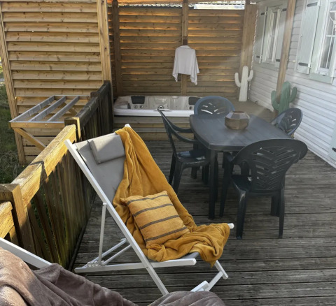 Premium Mobile Home terrasse ved Campsite Les Franquettes med loungestole, bord, og boblebad i Frankrig.