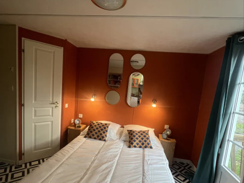 Premium Mobile Home soveværelse på Camping Les Franquettes i Frankrig, med moderne indretning og spejle.